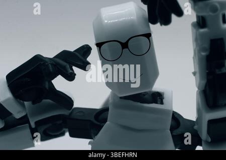 Super cute robot wearing glasses and smiling at the camera. Stock Photo