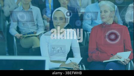 Image of digital displays with scanning icons over multiracial business people in seminar Stock Photo