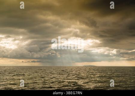 Sunbeams piercing through an opening in the clouds above Lake Nicaragua, Nicaragua Stock Photo