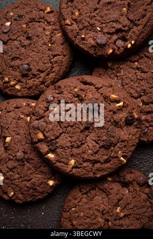 Chocolate chip cookies with hazelnuts as background. Texture of chocolate brownie cookies close up. Stock Photo