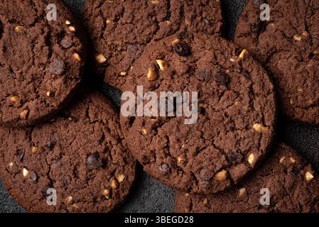 Chocolate chip cookies with hazelnuts as background. Texture of chocolate brownie cookies close up. Stock Photo
