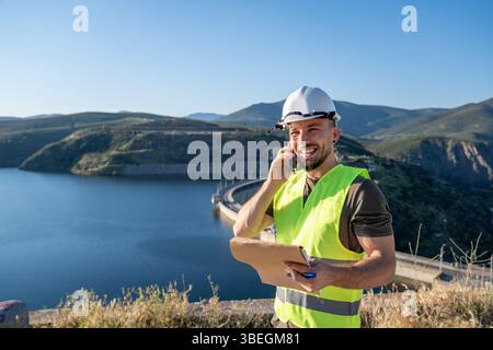 Engineer talking on phone at hydroelectric power plant dam Stock Photo