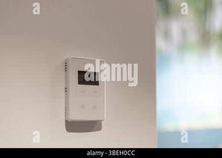 A digital thermostat is mounted on a wall displaying a temperature of 22.6 degrees Celsius. The setting indicates a comfortable climate in a Stock Photo