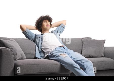 Relaxed young man enjoying on a sofa isolated on white background Stock Photo