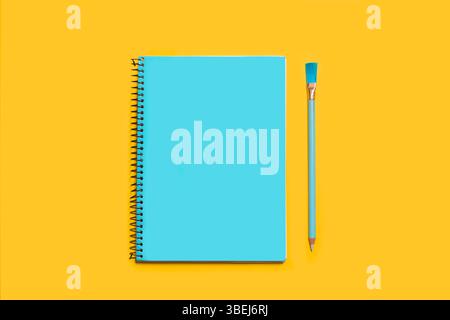 Open notebook in a turquoise page and a turquoise pencil on a yellow background with copy space Stock Photo