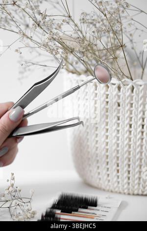 Elegant Dental Tools with Floral Decor A minimalist composition featuring pink and clear mascara wands arranged on a light surface, accompanied by Stock Photo