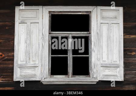 Rustic wooden window shutter. Vintage countryside architecture. Old painted surface texture. Weathered natural wood design. Closed farmhouse detail. Stock Photo