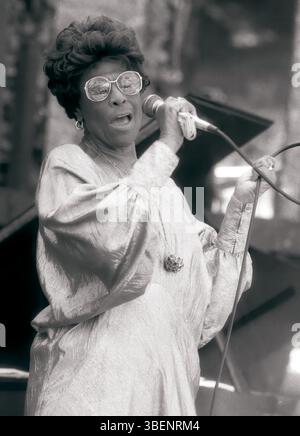 Ella Fitzgerald performing live in 1986. Ella Jane Fitzgerald (April 25, 1917 – June 15, 1996) was an American singer, songwriter and composer, sometimes referred to as the "First Lady of Song", "Queen of Jazz", and "Lady Ella". She was noted for her purity of tone, impeccable diction, phrasing, timing, intonation, absolute pitch, and a "horn-like" improvisational ability. Image Own work, CC BY-SA 4.0, https://commons.wikimedia.org/w/index.php?curid=91721605 Stock Photo
