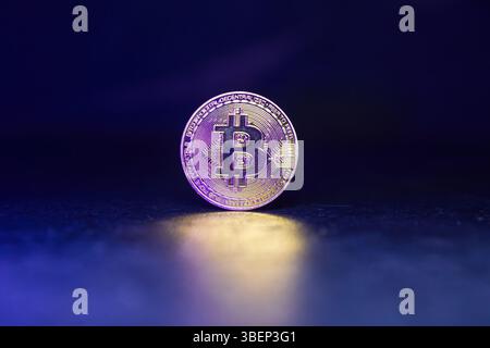 Bitcoin with Golden Glow Reflected on Surface Stock Photo