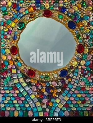 Round mirror surrounded by colorful jewels. Jeweled mirror. Stock Photo