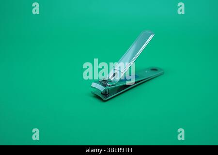 Stainless nail clippers on a green background. Stock Photo