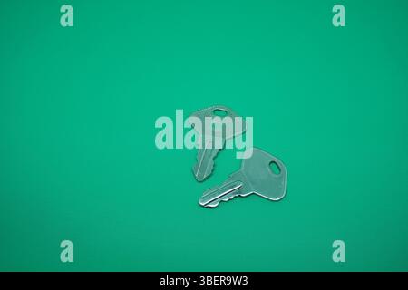 Two pair stainless key isolated on green. Stock Photo