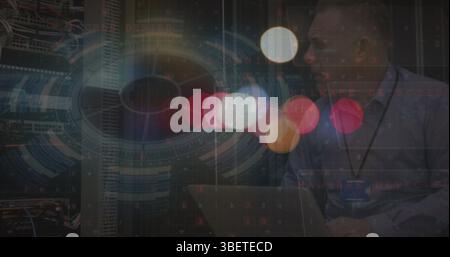 Image of blurred traffic lights over processing circle over caucasian man checking servers Stock Photo