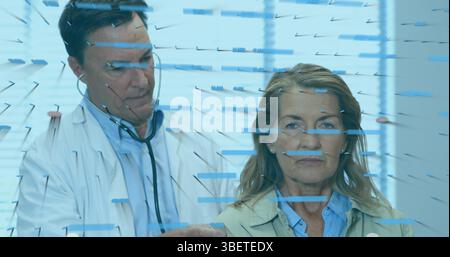 Financial data processing against caucasian male doctor examining caucasian senior female patient Stock Photo