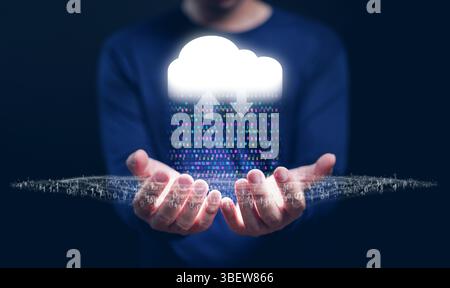 Cloud Computing Concept – A man with cloud technology in his hand delivering IT resources as binary code via the Internet with data streams, networkin Stock Photo