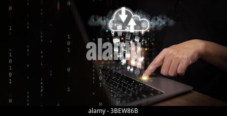 Cloud Computing Concept – A man uses laptop computer to upload and download IT resources via cloud technology, featuring binary code, data streams, ne Stock Photo