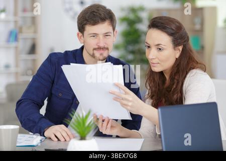 couple holding reading financial documents checking paying household bills Stock Photo