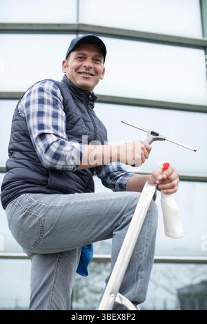 male cleaner washes windows and store front Stock Photo