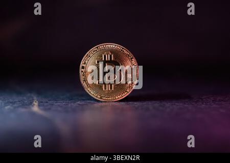 Bitcoin with Golden Glow Reflected on Surface Stock Photo