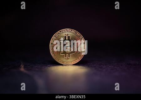 Bitcoin with Golden Glow Reflected on Surface Stock Photo