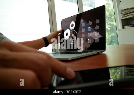 A business professional interacting with digital interfaces and modern devices, showcasing automation technology with gears and document icons. The co Stock Photo