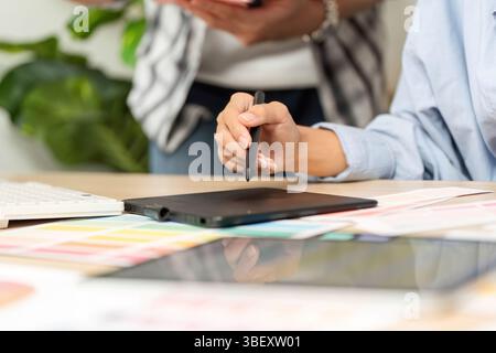 UX and UI Design Collaboration. Creative professionals brainstorming with digital tablet. Stock Photo