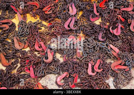 Old rusty chains with hooks for fastening lie on the deck. View from above. Stock Photo