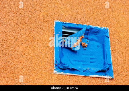 There is an orange wall that features a blue square painted prominently on its surface, adding a vibrant contrast to the setting Stock Photo