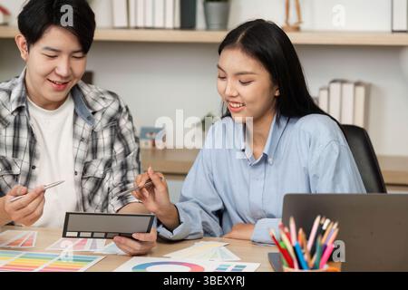 UX and UI Design Collaboration. Two designers discussing color palettes and layouts. Stock Photo