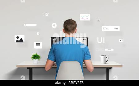 Web designer or developer seated in front of a laptop, seen from behind, actively working on a site interface. Around the desk float various UI elemen Stock Photo