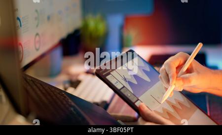 Business Analyst Using Digital Pen Review Technical Charts in Modern Office digital stylus interact displaying data charts contemporary office workspa Stock Photo