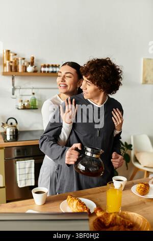Couple shares laughter and affection while preparing breakfast in their inviting, sunlit kitchen. Stock Photo