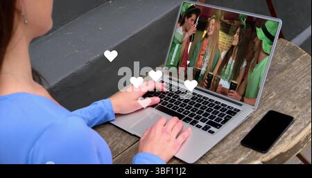 Online marketing text and multiple digital icons over caucasian woman with documents using laptop Stock Photo