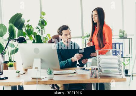 Team members discussing project details in a modern office space, collaborating effectively for business success Stock Photo