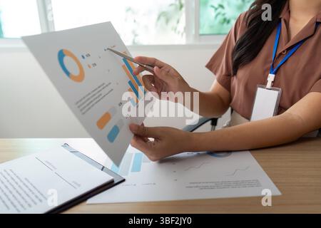 Data Presentation. Professional analyzing financial reports and graphs in a modern office. Stock Photo
