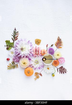 A vibrant autumn still life flatlay with flowers, leaves, teacup and teaspoon and empty space Stock Photo