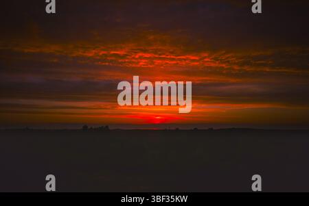Colorful sunset with dramatic clouds and glowing horizon Stock Photo
