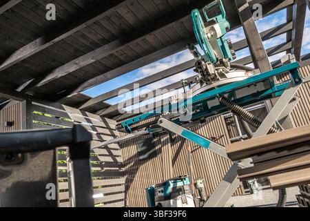 High-quality carpentry tools are set up in a spacious workshop featuring slatted walls and ample natural light coming through open skylights. Stock Photo
