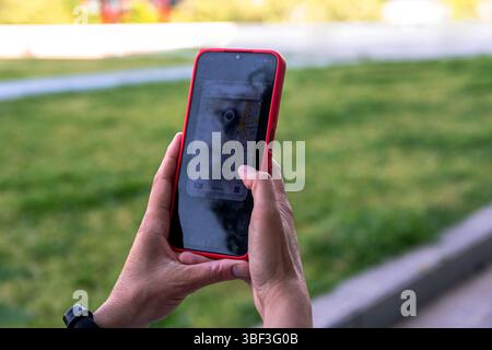 Woman using navigation app on smartphone in park Stock Photo