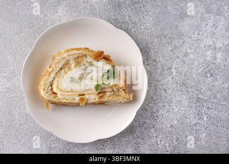 Meringue roll with pear and mint on a white plate, copy space Stock Photo