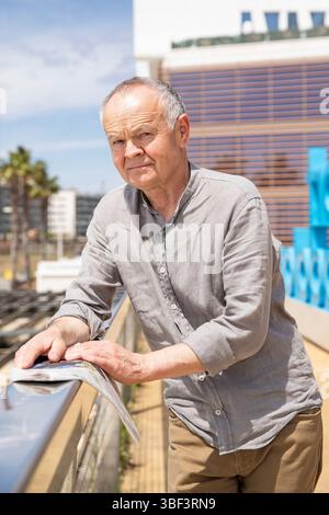 Older man smiling under sunlight. man in shirt Stock Photo