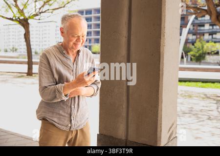 Senior man using smartphone outdoors. Man with phone Stock Photo
