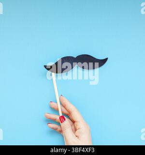 Creative square flatlay top view retro black paper photo booth props moustaches woman hands turquoise background copy space Men health awareness month Stock Photo