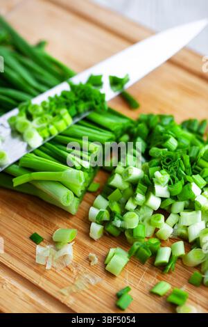 Fresh green onions on a wooden cutting board, kitchen still life Stock Photo