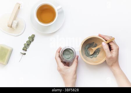 Spa, beauty cosmetics and body care treatment concept with copy space. Creative top view flat lay composition cup of tea, green spirulina cleansing ma Stock Photo