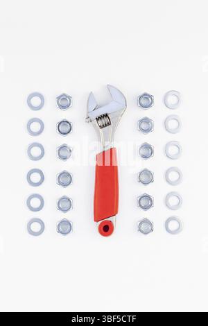 Creative knolling Flat lay of metal nuts and spanner on white background with copy space. Repair or improvement top view concept Stock Photo