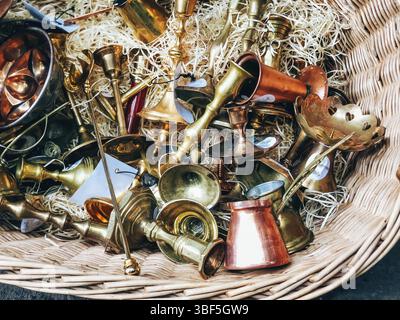 Antique brass and copper musical instruments in wicker basket, detailed texture Stock Photo