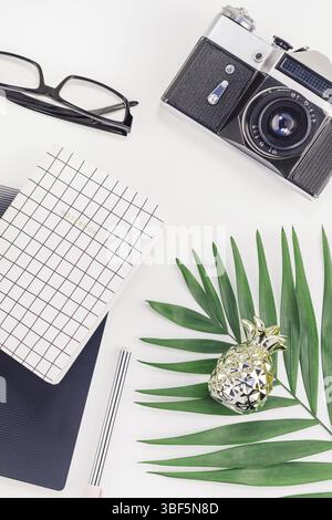 Top view flat lay office workspace desk styled design office supplies tropical palm leaves smartphone camera copy space black white background. Templa Stock Photo