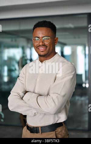 Happy young African American business man standing in office, portrait. Stock Photo