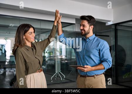 Happy business team of two people man and woman giving high five. Stock Photo